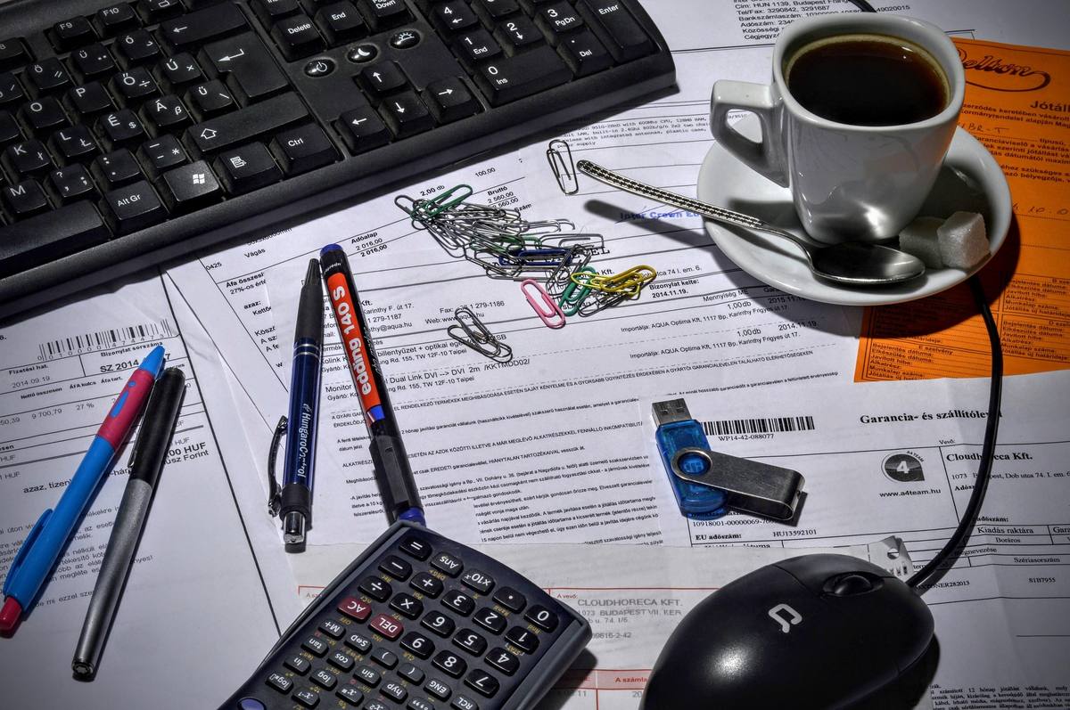 Facturas, calculadora y café en un escritorio de contabilidad básica